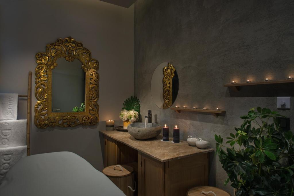 Elegants un relaksējošs spa interjers ar izsmalcinātu zelta spoguli, sveču gaismu un dabīgiem elementiem. Ideāla vide, lai atgūtu mieru un harmoniju.