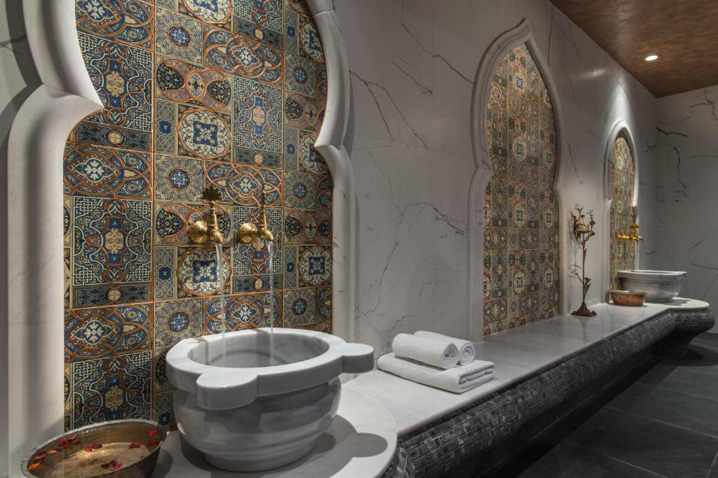 Eleganta interjera dizains ar ornamentiāliem flīzēm un marmora izstrādājumiem, radot relaksējošu atmosfēru. Šī telpa ir ideāla atpūtai un labsajūtai.