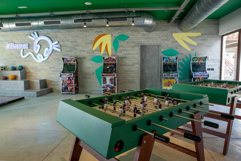 Futbola galda spēļu zona ar spilgtām krāsām un retro spēļu automātiem, radot jautru un relaksējošu atmosfēru. Ideāla vieta izklaidei un atpūtai.