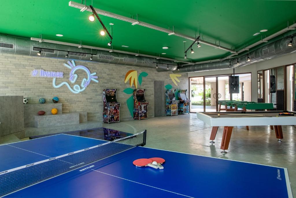 Mūsdienīga izklaides telpa ar galda tenisa galdu, biljarda galdu un retro spēļu automātiem. Sienā iekļauta gaismas instalācija ar uzrakstu "#livenex".
