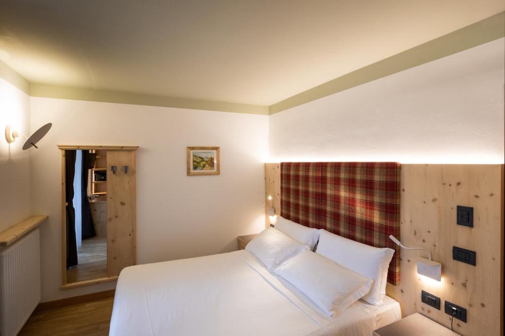 Mūsdienīgi iekārtota guļamistaba ar ērtu gultu un koka akcentiem, kas rada mājīgu atmosfēru. Sienas dekorētas ar attēlu un apgaismojums uzsver telpas komfortu.