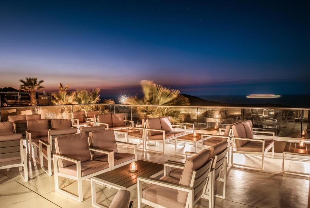 Blue Bay Resort Crete terase ar komfortablām mēbelēm piekrastē saulrieta laikā