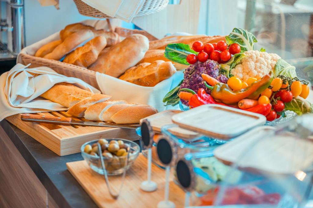 Bagetes un dārzeņu izlase, kas skaisti pasniegta uz galda. Izteiksmīga krāsu palete ar svaigiem dārzeņiem un maizi, kas veido appetītes veidojošu skatu.