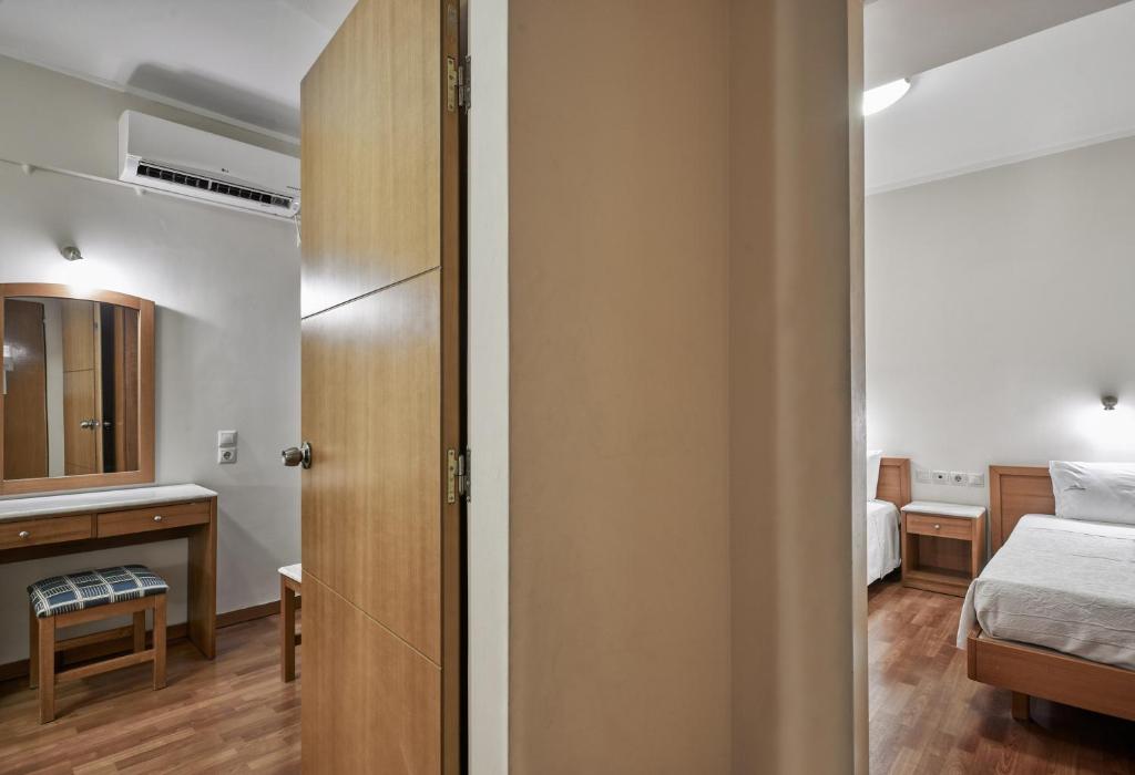 Mūsdienīgs viesnīcas numurs ar gultām, koka mēbelēm un spoguli, kas piedāvā ērtu atpūtu. Gaismas krāsas un silts apgaismojums rada mājīgu atmosfēru.