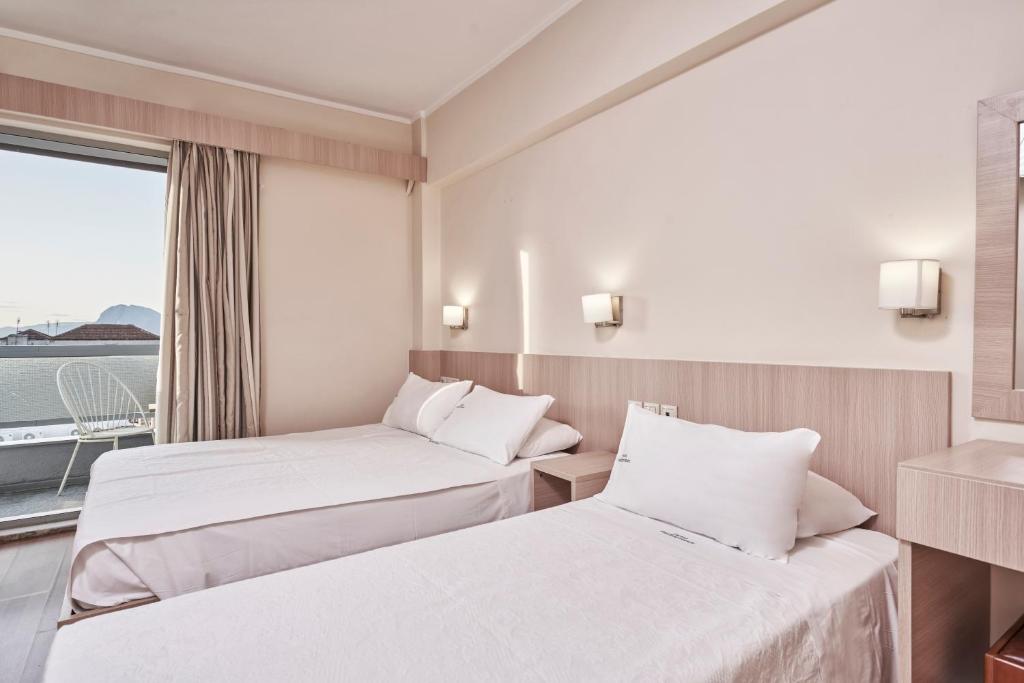 Moderns viesnīcas numurs ar divām atsevišķām gultām un balkonu. Telpā ir gaišas krāsas interjers un lieli logi, kas nodrošina dabisko apgaismojumu.