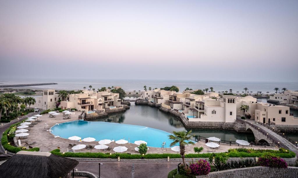 The Cove Rotana Resort piekrastē ar baseinu un arhitektūru.