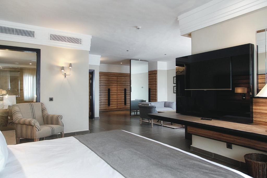 Mūsdienīgs viesnīcas numurs ar elegantu interjeru, ieskaitot ērtu atpūtas krēslu, plakanā ekrāna televizoru un stilīgas mēbeles. Gaismas un telpas struktūra rada patīkamu atmosfēru.