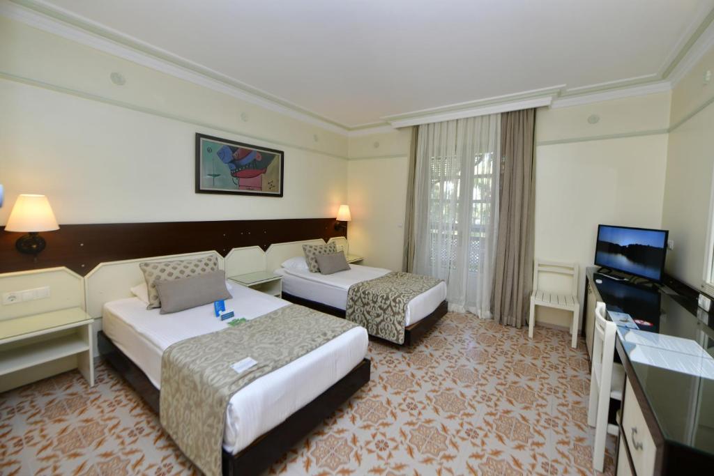 Numurs ar divām gultām viesnīcā Ali Bey Club, gaišs un mājīgs.