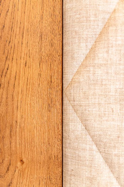 Koka un auduma kombinācija ar dabīgu struktūru, kas rada harmonisku vizuālo kontrastu. Ideāli piemērota interjera dizainam.