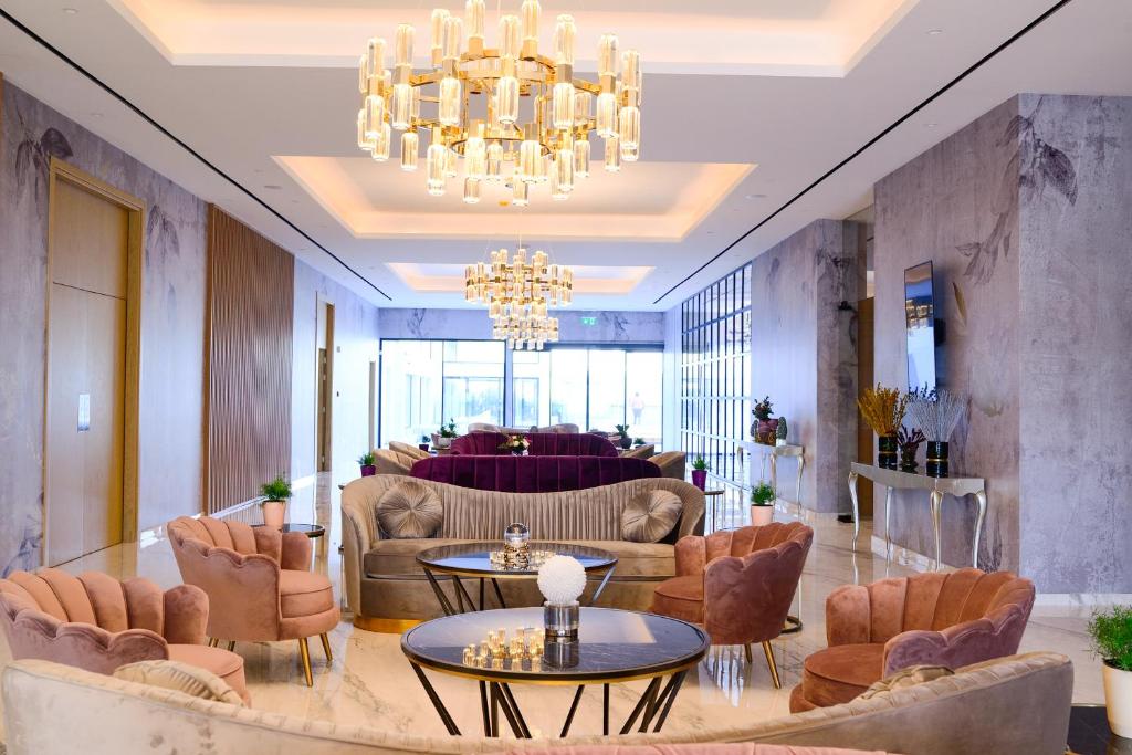 Mūsdienīgs viesnīcas vestibils ar elegantiem dīvāniem un greznām lustām, radot elegantu un aicinošu atmosfēru. Interjers ir izsmalcināti dekorēts, piedāvājot komfortablu atpūtu.