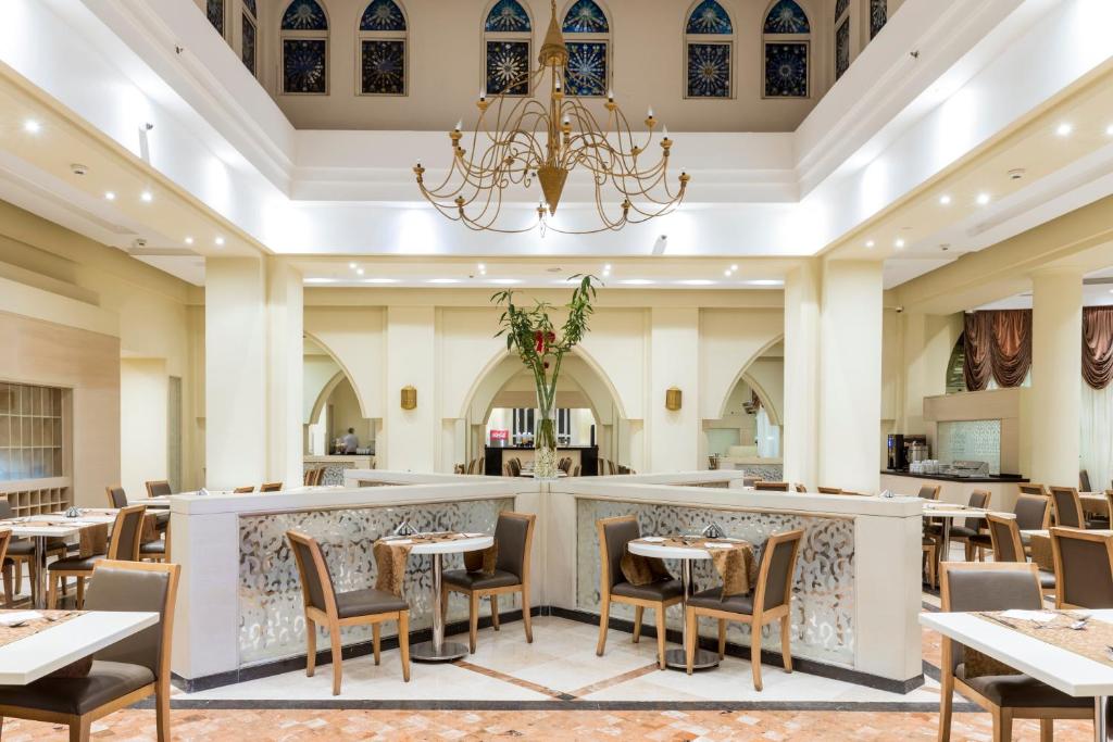 Elegantā restorāna interjers ar izsmalcinātu apgaismojumu un modernām mēbelēm, kas rada patīkamu atmosfēru. Uzsvars uz plašumu un dizaina detaļām.