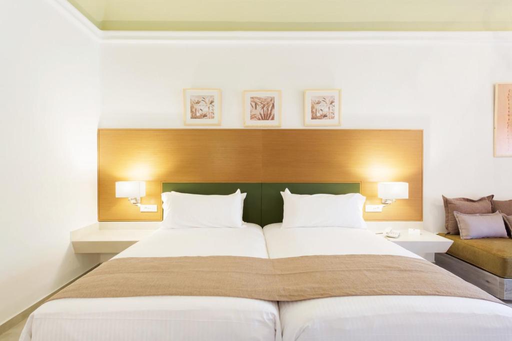 Mūsdienīga viesnīcas numura interjers ar divām gultām, mēbelēm un mākslas darbiem uz sienām. Ideāla izvēle atpūtai un komfortam.