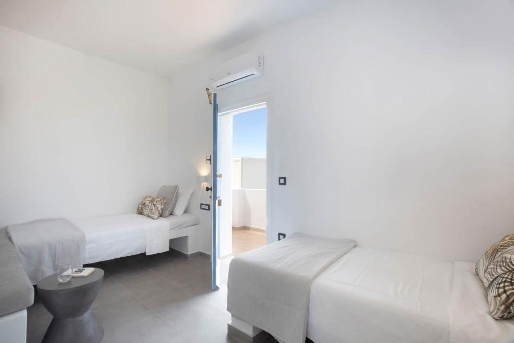 Gaiša un mūsdienīga guļamistaba ar divām gultām, kuras apgaismo dabīgā gaisma, un durvīm, kas ved uz balkonu. Telpa ir dekorēta ar neitrālām krāsām un vienkāršiem mēbeļu elementiem.