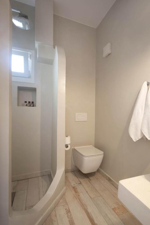 Mūsdienīgs vannas istabas interjers ar dušu, tualeti un gaišām flīzēm. Telpa ir gaiša un funkcionāla, radot patīkamu atmosfēru.