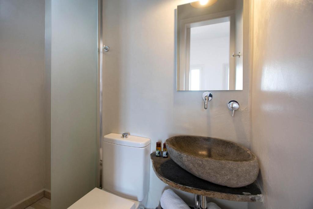 Mūsdienīgs vannas istabas interjers ar akmens izlietni, stikla dušu un minimālistisku dizainu. Gaismas tonis rada gaišu un atvērtu atmosfēru.