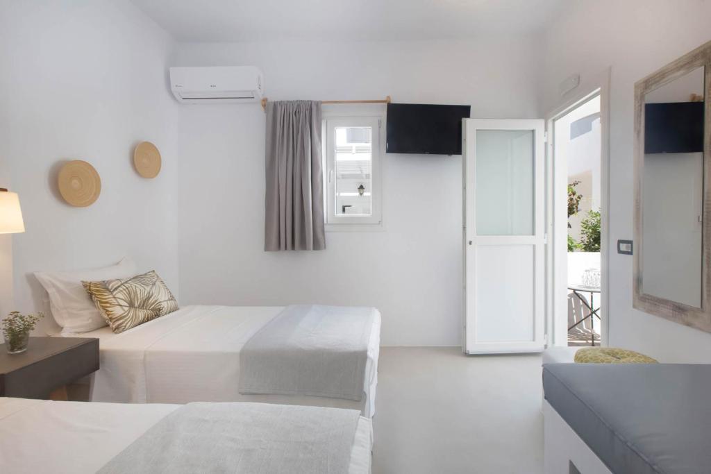 Mūsdienīgs viesnīcas numurs ar divām gultām, gaišām sienām un dabīgu apgaismojumu. Numurā ir televizors, gaisa kondicionieris un piekļuve terasei.