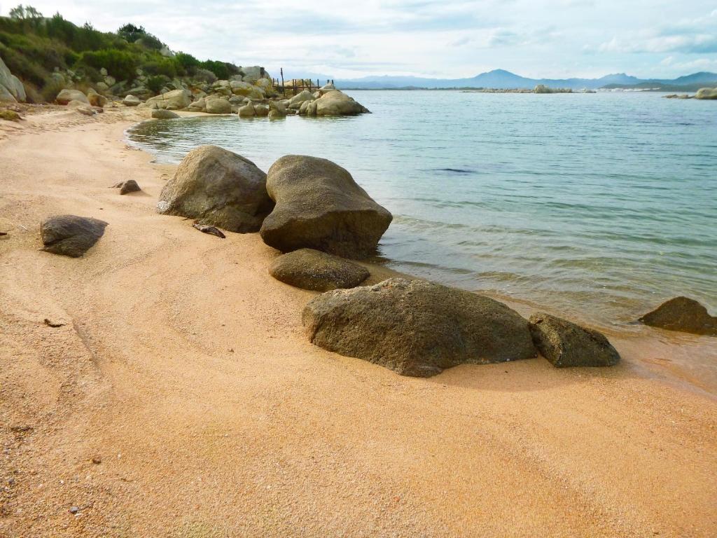 Smilšaina pludmale ar klintīm pie Cala Cuncheddi.