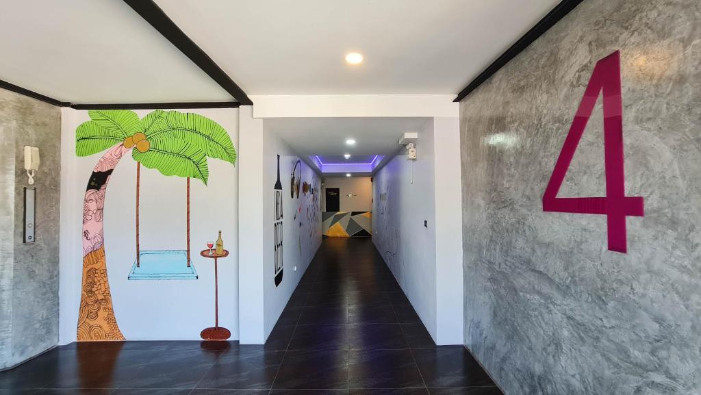Dzīvojamā telpā ir stilīgs interjers ar zīmējumu, kas attēlo palmu un šūpuļtīklu, kā arī spilgti rozā numura 4. Apgaismojums un mūsdienīga flīžu grīda piešķir telpai modernu izskatu.