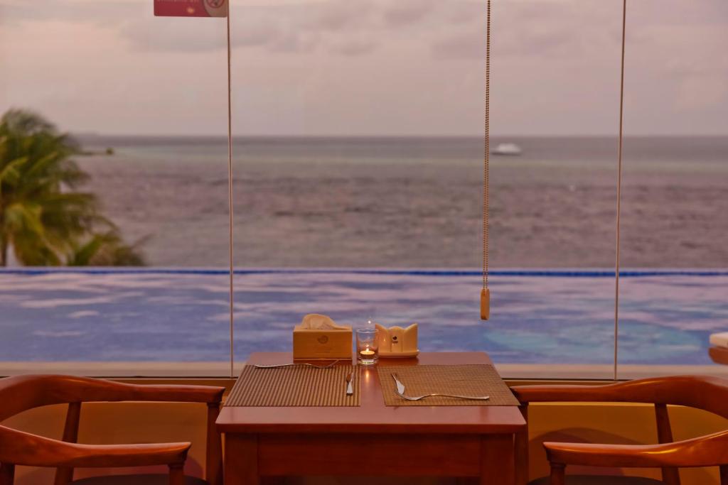 Romantiska skatu uz jūru no restorāna, kur uz galda ir galda piederumi un svece.