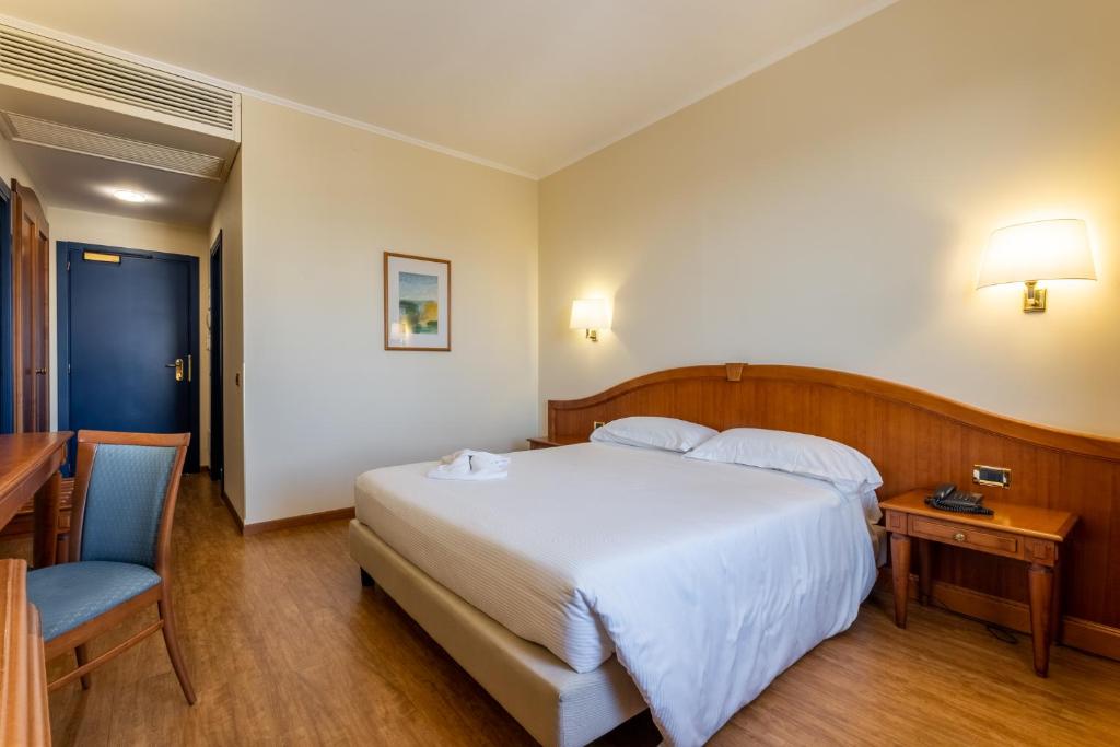 Mūsdienīgs viesnīcas numurs ar divguļamo gultu, koka mēbelēm un rakstāmgaldu. Telpā ir siltas krāsas un dabīga apgaismojuma elementi.