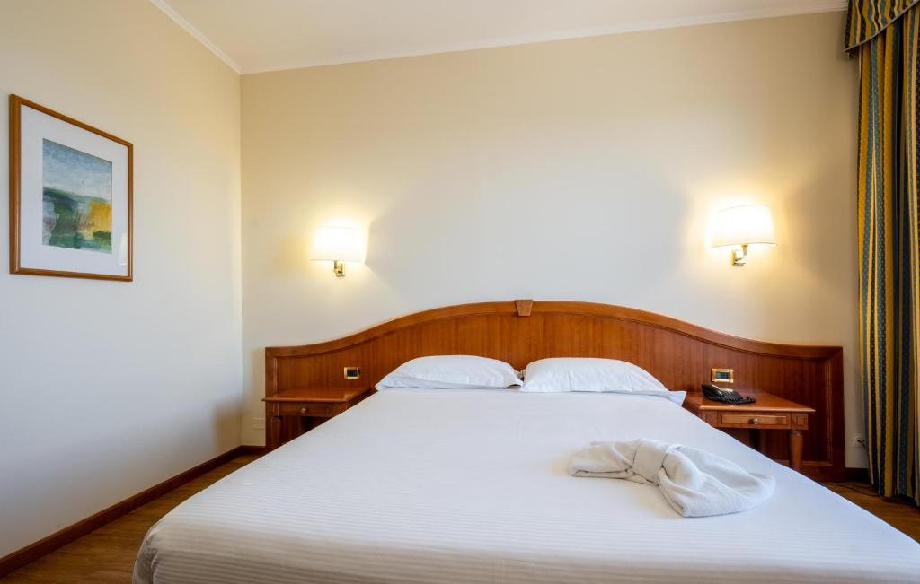 Mūsdienīgs viesnīcas numurs ar divguļamo gultu, koka galdu un gaismas avotiem. Sienā ir mākslas darbs, un logi ir aizklāti ar stilu atbilstošām aizkariem.