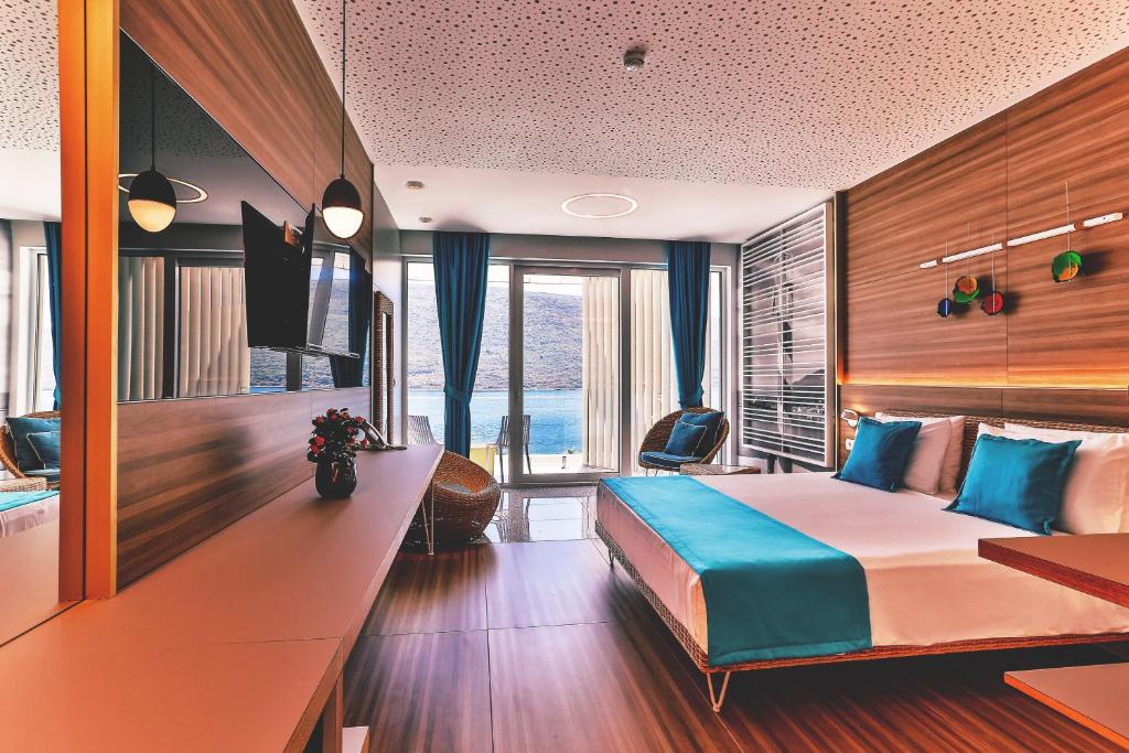 Mūsdienīga viesnīcas numura interjers ar panorāmas skatu, koka apdari un krāsainiem aksesuāriem. Telpā ir liela gulta, televizors un ērtas mēbeles, kas nodrošina relaksējošu atmosfēru.