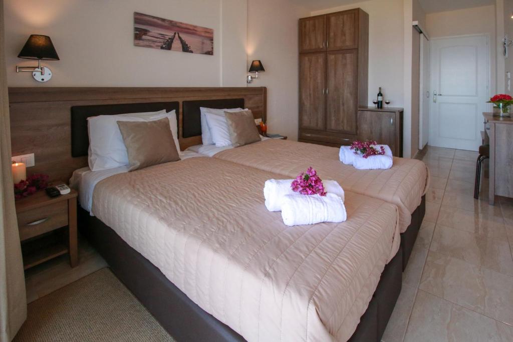 Mūsdienīgs viesnīcas numurs ar divām gultām, dekorēts ar ziediem un mīkstiem spilveniem. Telpa ir gaiša un ērta, ar koka mēbelēm un modernu interjeru.