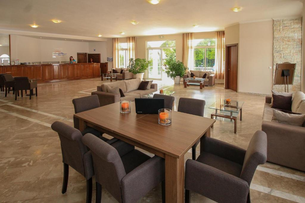 Moderns viesnīcas vestibils ar elegantiem mēbeļu komplektiem, atpūtas zonu un saulainu gaismu, kas ieplūst caur lielajiem logiem. Ideāla vieta relaksācijai un socializācijai.