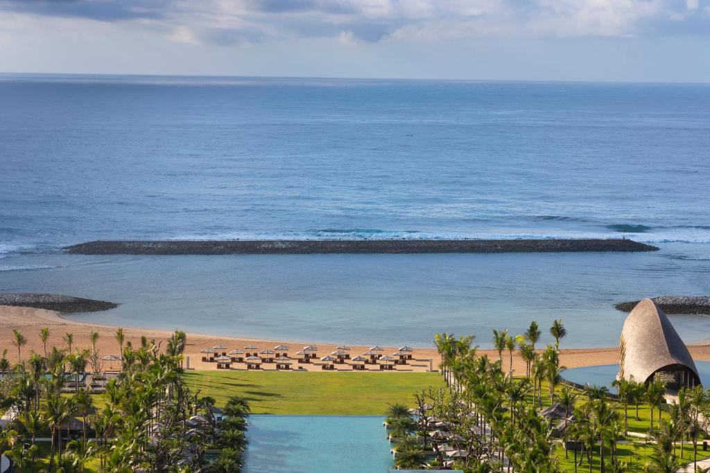 Tropu pludmale ar palmām un sauļošanās krēsliem, blakus mierīgai zilai lagūnai un okeānam. Ideāla vieta relaksācijai un atpūtai.