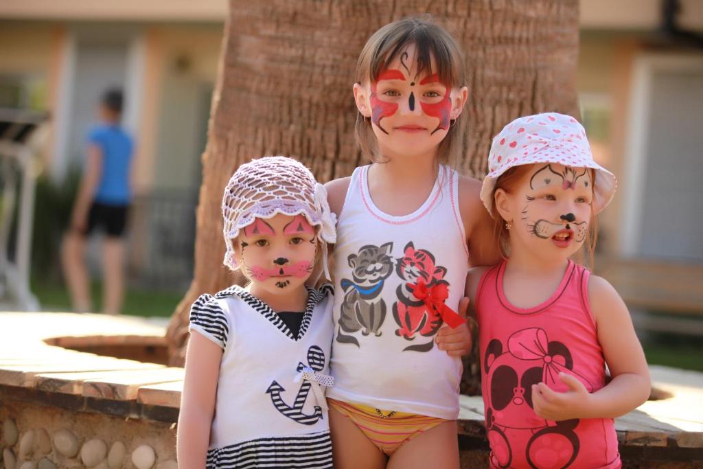 Bērni ar krāsainām sejām izklaidējas pie Camyuva Beach Hotel.