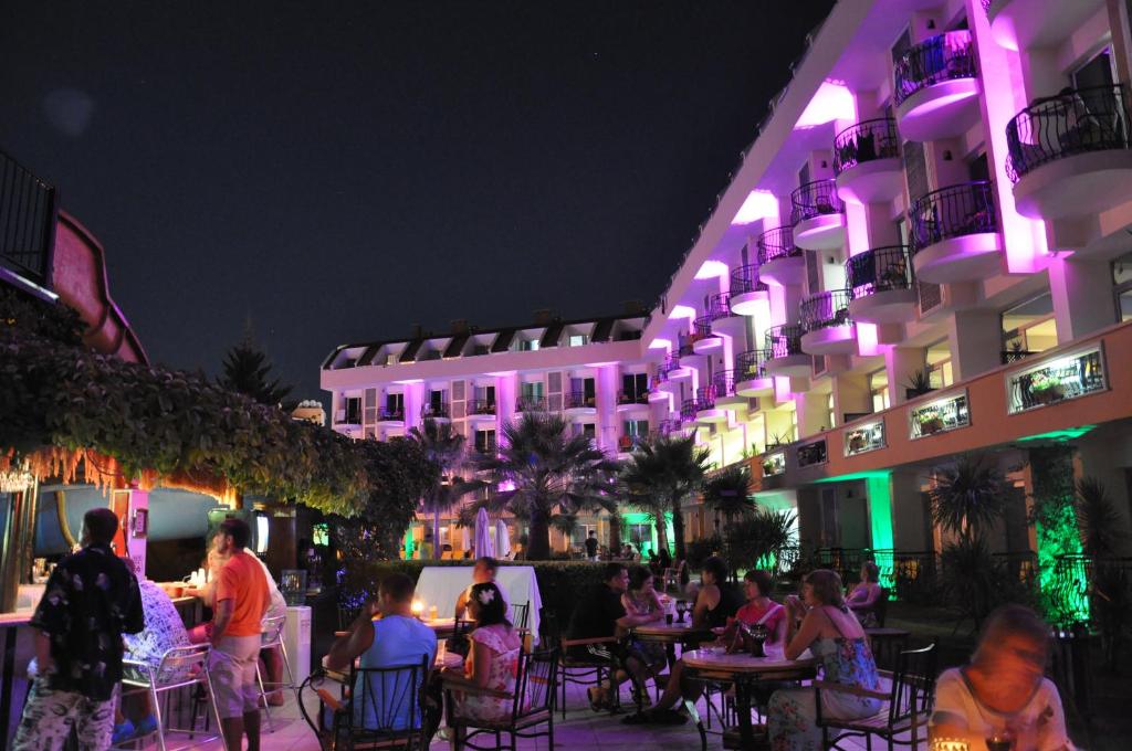 Viesnīca Camyuva Beach Hotel ar nakts apgaismojumu un viesiem, kas izbauda vakaru.