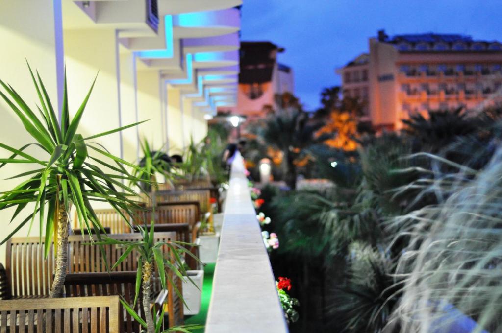 Camyuva Beach Hotel terase ar augiem un koka mēbelēm vakara gaismā