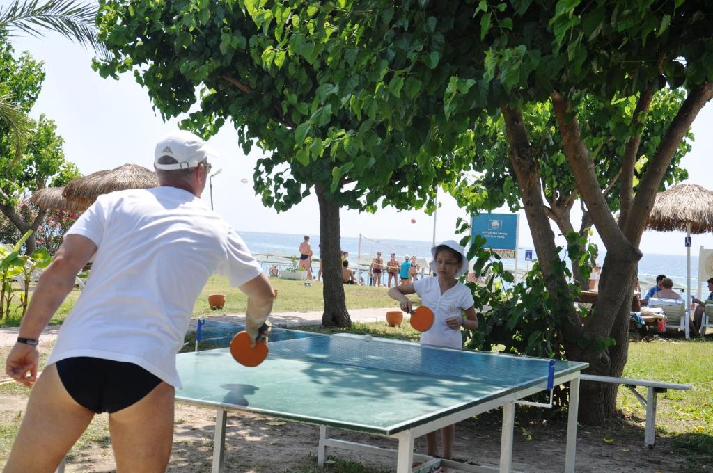 Bērns un pieaugušais spēlē galda tenisu pie Camyuva Beach Hotel.