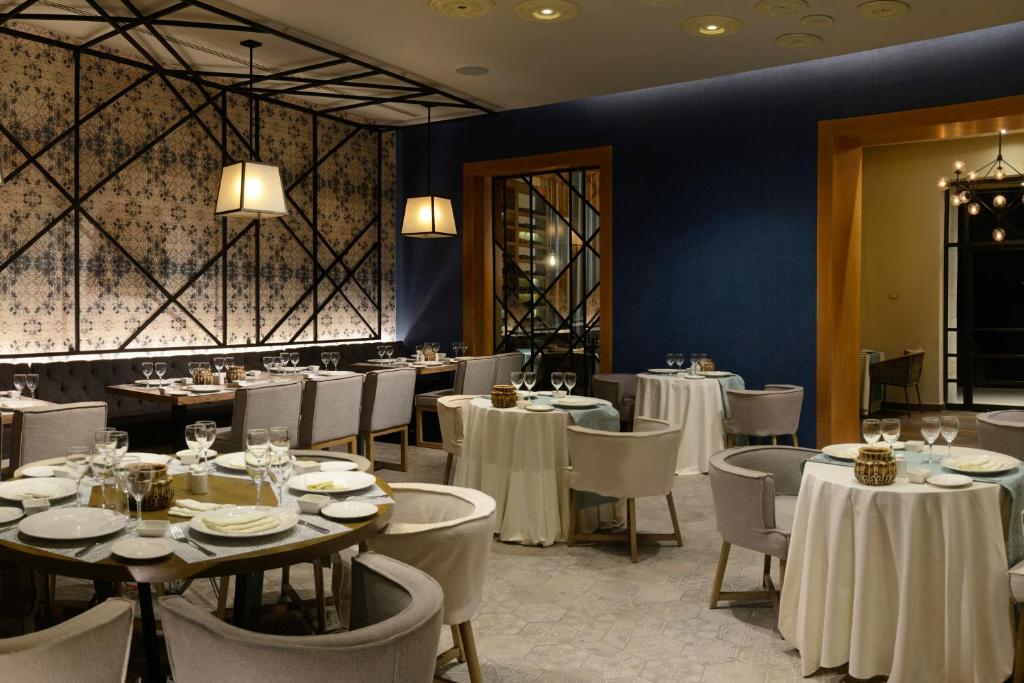 Mūsdienīgs restorāns ar elegantiem galdiem un krēsliem, dekorēts ar stilīgu tapeti un apgaismojumu. Ideāla vieta romantiskām vakariņām vai svinībām.