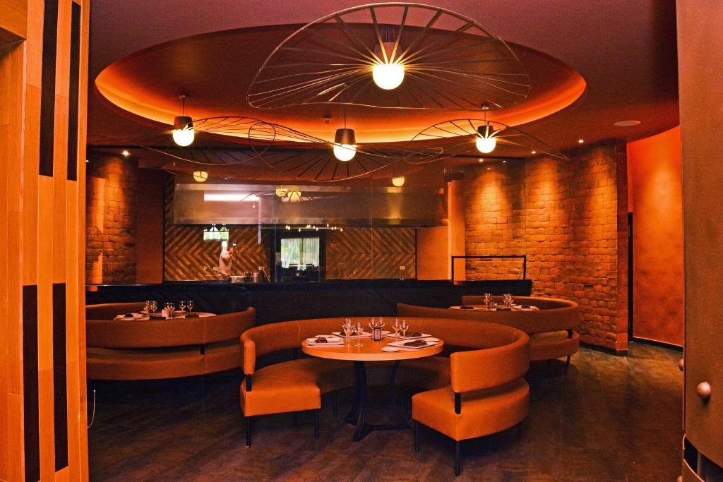 Siltināts, mūsdienīgs restorāna interjers ar apaļām galdiem un komfortablām dīvāniem, izceļoties ar radošām gaismas instalācijām un siltām krāsām. Ideāla vieta relaksējošiem vakariem.