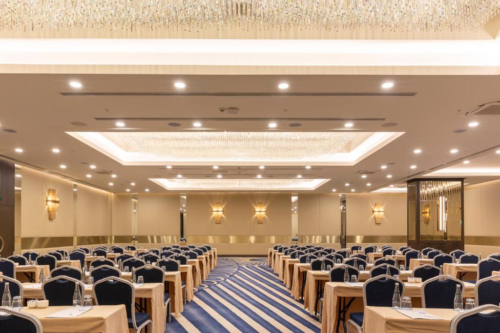 Konferences telpa ar elegantiem galdiem un krēsliem, apgaismojumu un modernu dizainu. Telpa ir gatava uzņēmuma pasākumiem vai sanāksmēm.