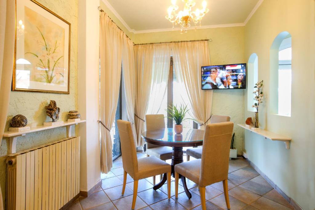 Mūsdienīga ēdamistaba ar apaļu galdu, četriem krēsliem, televizoru un dabiskiem elementiem, piemēram, augiem un dekoratīvām figūrām. Gaisīga atmosfēra ar dabiskiem apgaismojumiem un maigiem toņiem.