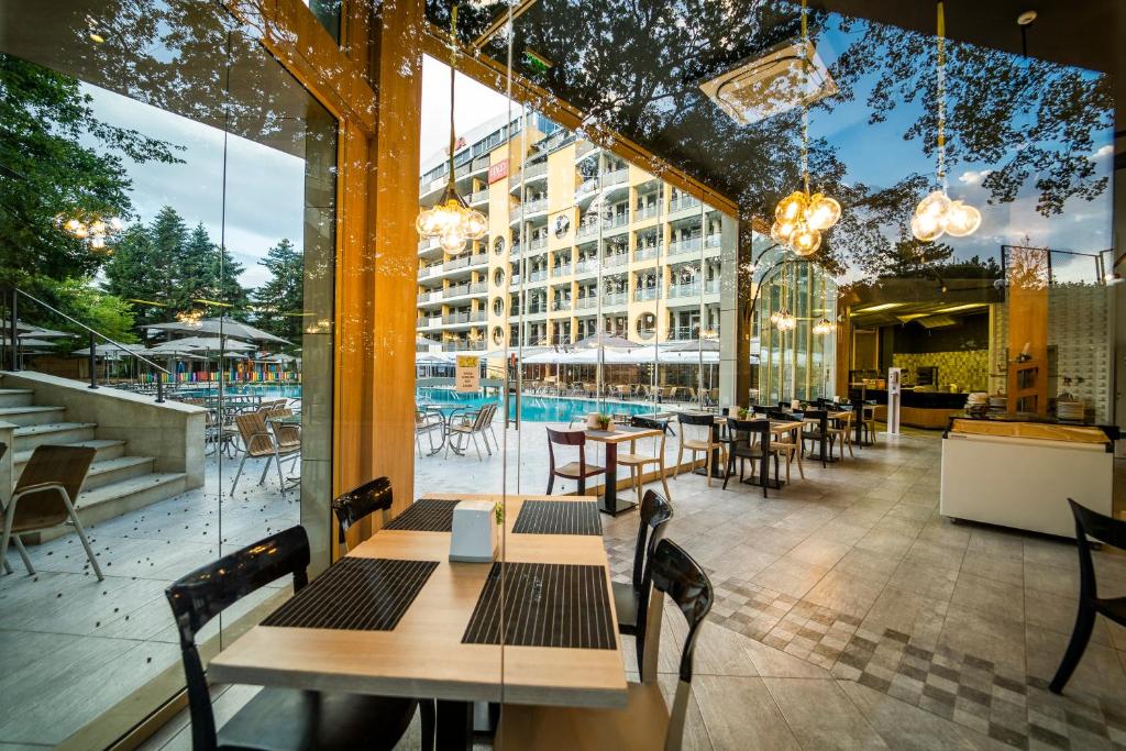 Mūsdienīgs restorāns ar stikla sienām, kas sniedz skatu uz peldbaseinu un terasi. Interjers ir elegants ar koka akcentiem un modernām gaismām.