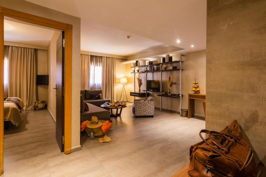 Mūsdienīgs viesnīcas numurs ar viesistabu un guļamistabu, kurā ir dabiska apgaismojuma avoti un stilīgs interjers. Redzamas ērtas mēbeles un dekoratīvi elementi.