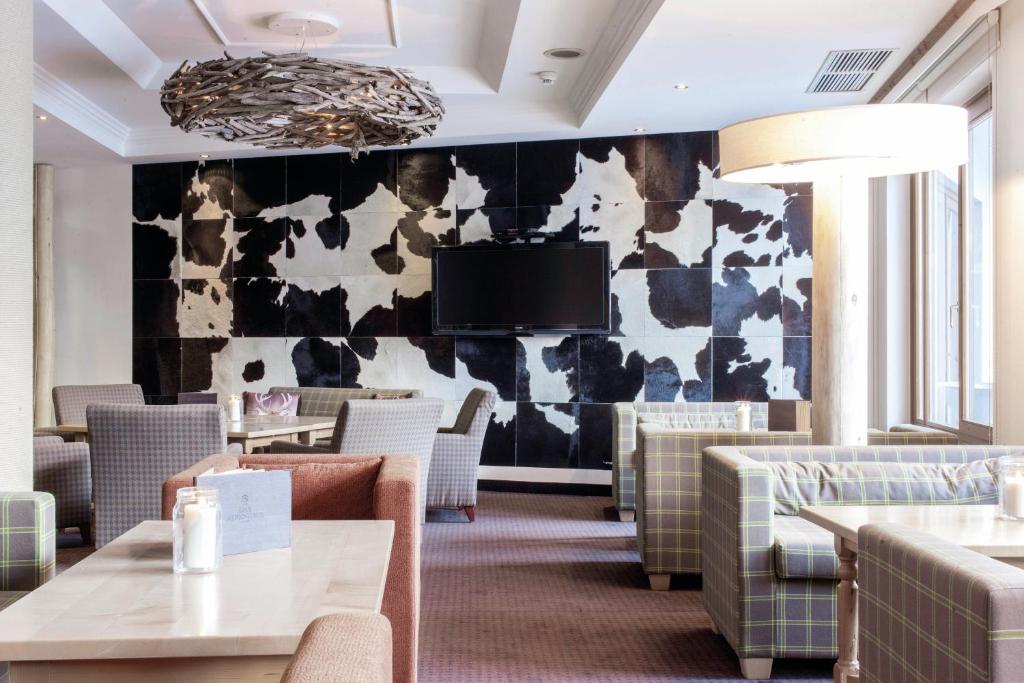 Mūsdienīgs interjers ar komfortablām mēbelēm un oriģinālu govju ādas akcentu uz sienas. Gaisma un telpas plānojums rada patīkamu atmosfēru.