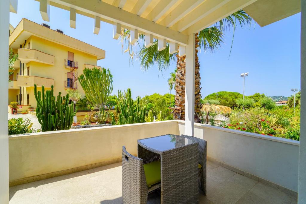 Terases skats ar galdu un krēslām, apkārt esošiem zaļumiem un ēkām, radot relaksējošu atmosfēru.