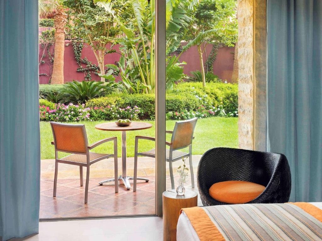 Mūsdienīga viesnīcas numura skats uz dārzu ar ērtām mēbelēm un zaļām augu kompozīcijām. Ideāla vieta atpūtai un relaksācijai.