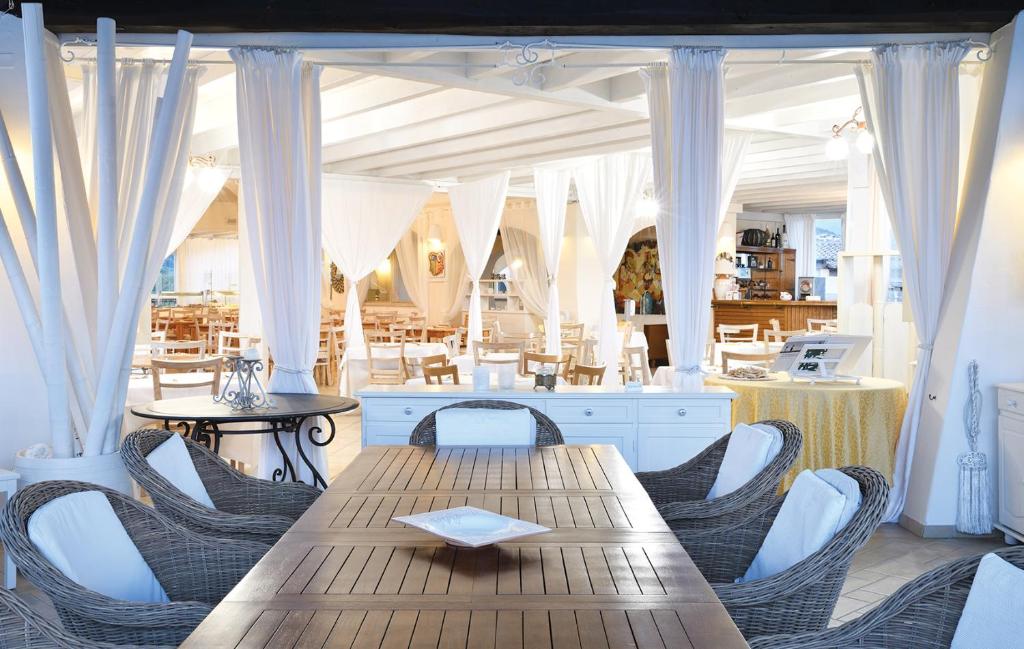 Elegants restorāns ar baltām drapējumiem Baia del Porto viesnīcā.