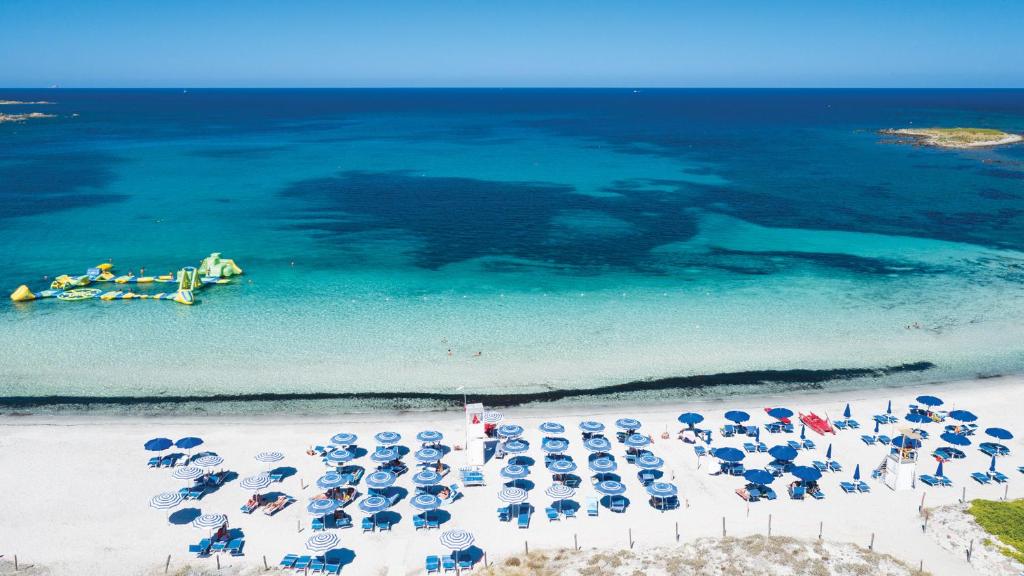 Baia del Porto pludmale ar sauļošanās krēsliem un skaidru ūdeni.
