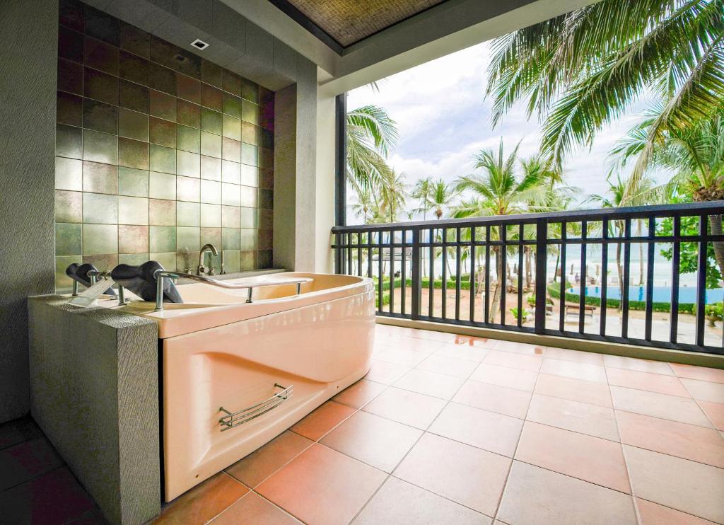 Liela vannas istaba ar jacuzzi, kas atrodas uz terases ar skatu uz palmu dārzu un jūru. Vannas istaba ir modernā stilā ar flīzēm un plašu telpu, kas nodrošina relaksējošu atmosfēru.