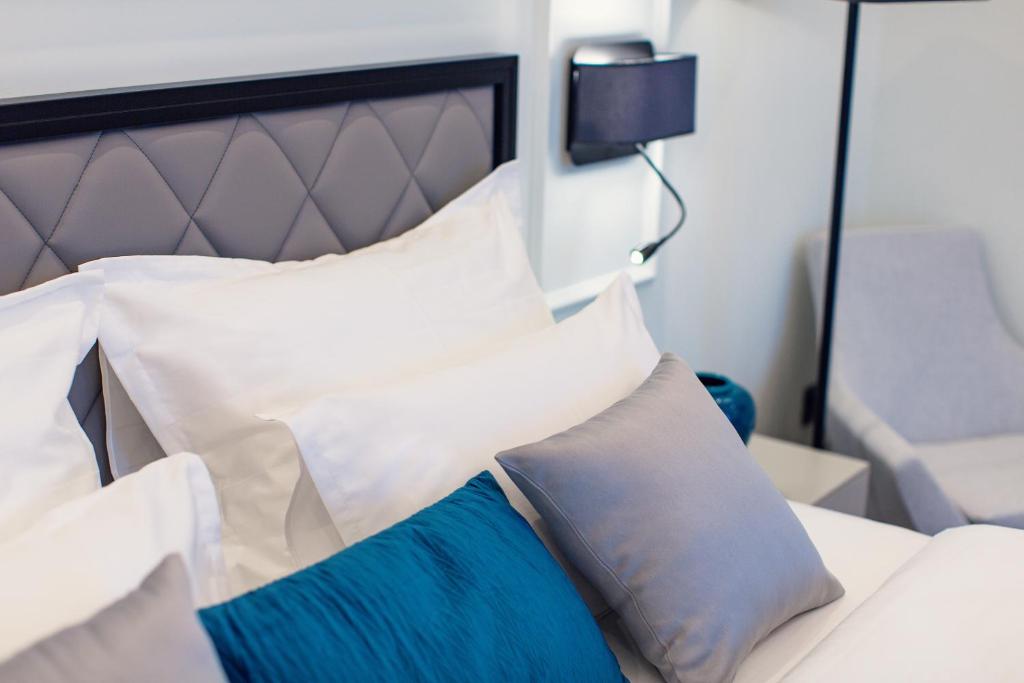 Mūsdienīgs guļamistabas interjers ar elegantu gultu, mīkstiem spilveniem un modernu apgaismojumu. Ideāla atmosfēra relaksācijai un komfortam.