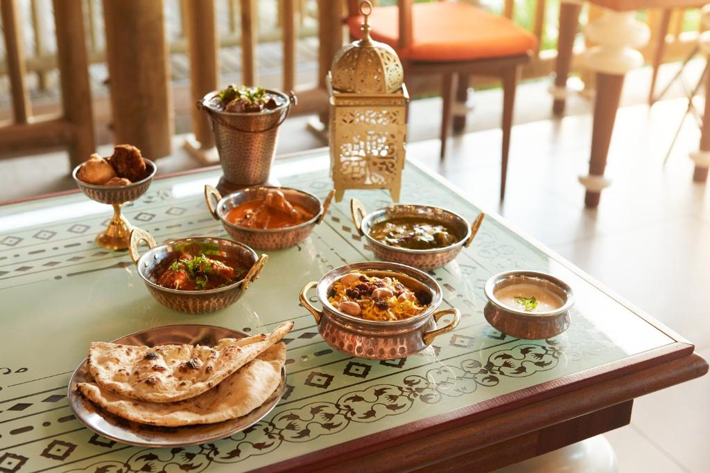 Tradicionāls indiāņu ēdiens, kas pasniegts uz galda, ietver dažādas maltītes metāliskos traukos, ko papildina nann maize un garšvielas.