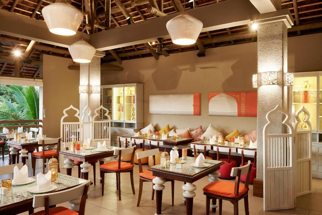 Elegants restorāns ar komfortablām galdiņām, kurā ir siltas krāsas un dekoratīvi elementi, radot patīkamu atmosfēru. Interjerā ir redzami izsmalcināti gaismas avoti un mīkstās sēdvietas.