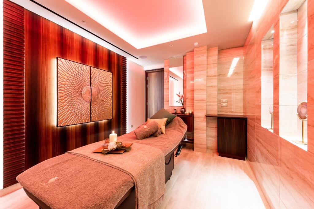 Adams Beach spa telpa ar masāžas galdu un nomierinošu apgaismojumu.