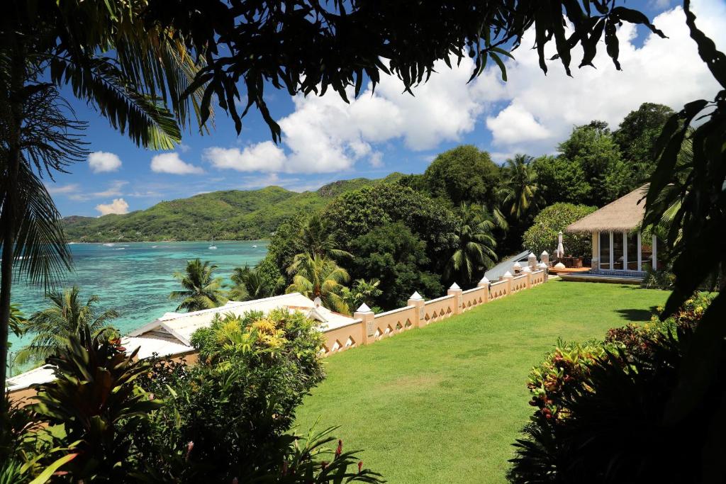 Tropu ainava ar zaļo zālienu, palmu kokiem un skatu uz zilo jūru un kalniem. Ideāla vieta relaksācijai un atpūtai pie dabas.